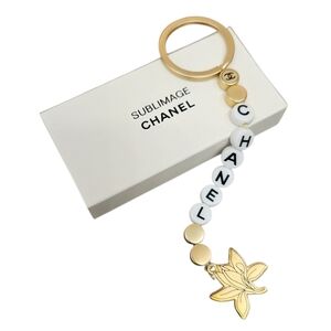 NIB CHANEL Sublimage Gold & White Beaded Keychain with Flower Charm